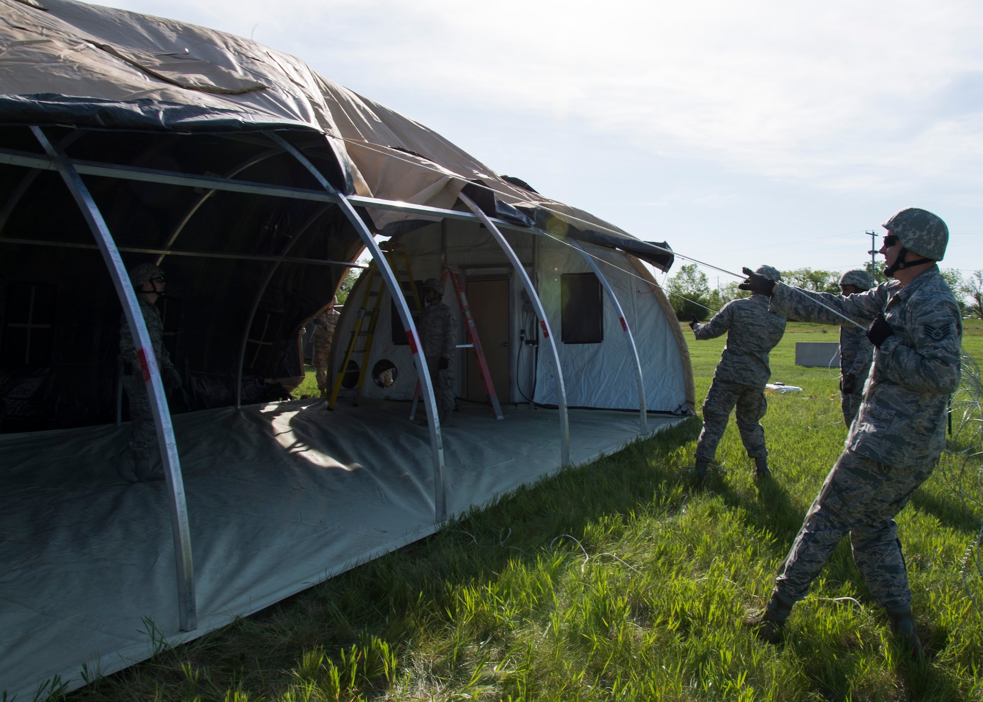Airmen from the 5th Civil Engineer Squadron build a tent at Minot Air Force Base, N.D., June 1, 2017. The 5th CES built two tents during Expeditionary Training Day, an event that prepares Airmen for potential deployment. (U.S. Air Force photo/Airman 1st Class Alyssa M. Akers)