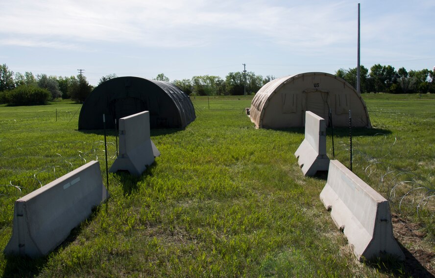 Airmen from the 5th Civil Engineer Squadron build two tents at Minot Air Force Base, N.D., June 1, 2017. The 5th CES hosted an Expeditionary Training Day for Airmen to help develop and maintain skill sets required for potential deployment. (U.S. Air Force photo/Airman 1st Class Alyssa M. Akers)