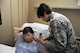 Lt. Col Candy Wilson (right), 779th Medical Group nurse practitioner, places a Nerve Scrambler electrode inches away from the source of nerve pain on the back of a patient’s neck May 30, 2017 at Joint Base Andrews, Md. Another electrode will be placed on the patient’s foot where she feels no pain. The low electrical current that passes through the electrodes to Grays body causes a “no pain” signal to override the existing pain signal being sent to the patient’s brain. (U.S. Air Force photo by Staff Sgt. Joe Yanik)