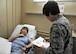 Lt. Col Candy Wilson (right), 779th Medical Group nurse practitioner, consults a human anatomy chart to determine where to place a Calmare electrode for treating Carol Celeste Gray, a Tricare beneficiary May 30, 2017 at Joint Base Andrews, Md. Gray suffers from chronic regional pain syndrome on the left side of her body that developed after being treated for a broken elbow. (U.S. Air Force photo by Staff Sgt. Joe Yanik)