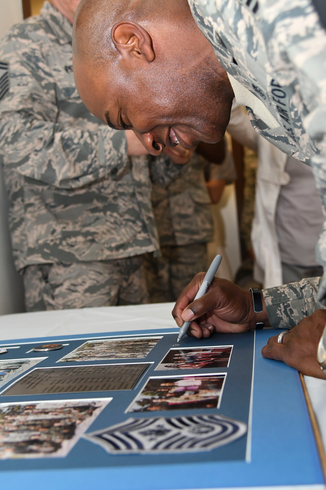 Chief Master Sgt. of the Air Force Kaleth O. Wright signs a picture while visiting the 51st Dental Squadron at Osan Air Base, Republic of Korea, June 7, 2017. Wright is a prior dental technician stationed at Osan and signed the photo to add to the Dental Clinic’s Hall of Fame. (U.S. Air Force photo by Airman 1st Class Gwendalyn Smith/Released)
