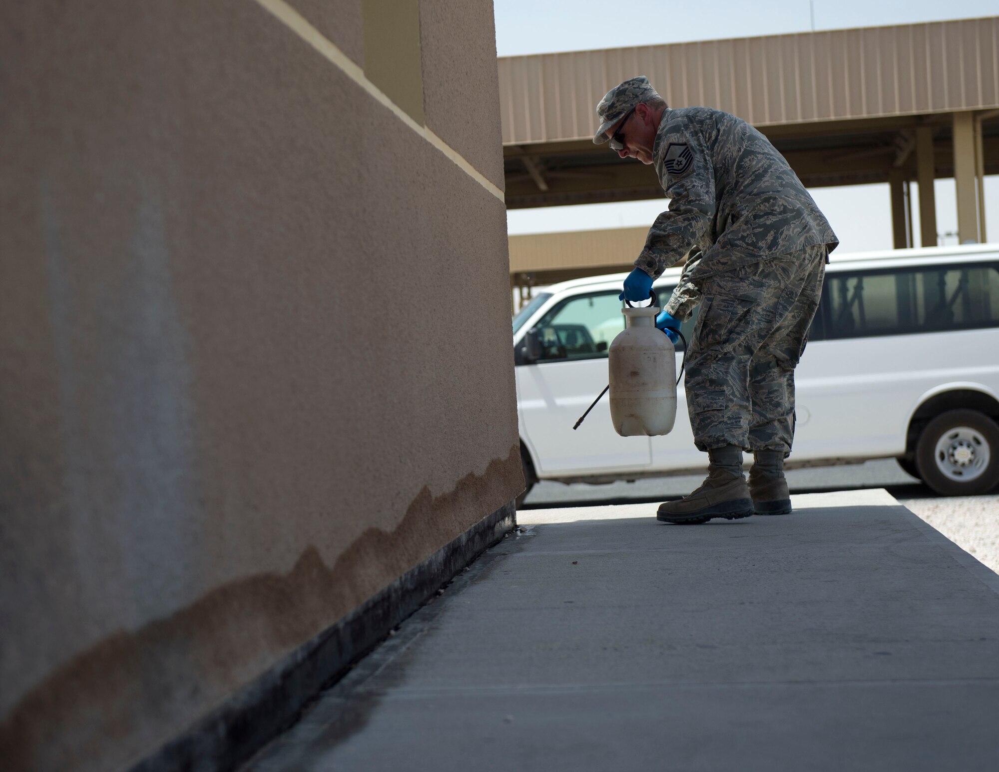 U.S. Air Force Master Sgt. Joseph Moore, non-commissioned officer in charge of pest management with the 379th Expeditionary Civil Engineer Squadron sprays insecticide around the perimeter of a building at Al Udeid Air Base, Qatar, May 30, 2017. Moore is part of a small team of airmen that keep the base free of pests which could carry infectious diseases in order to protect the health and safety of everyone on base. (U.S. Air Force photo by Tech. Sgt. Amy M. Lovgren)