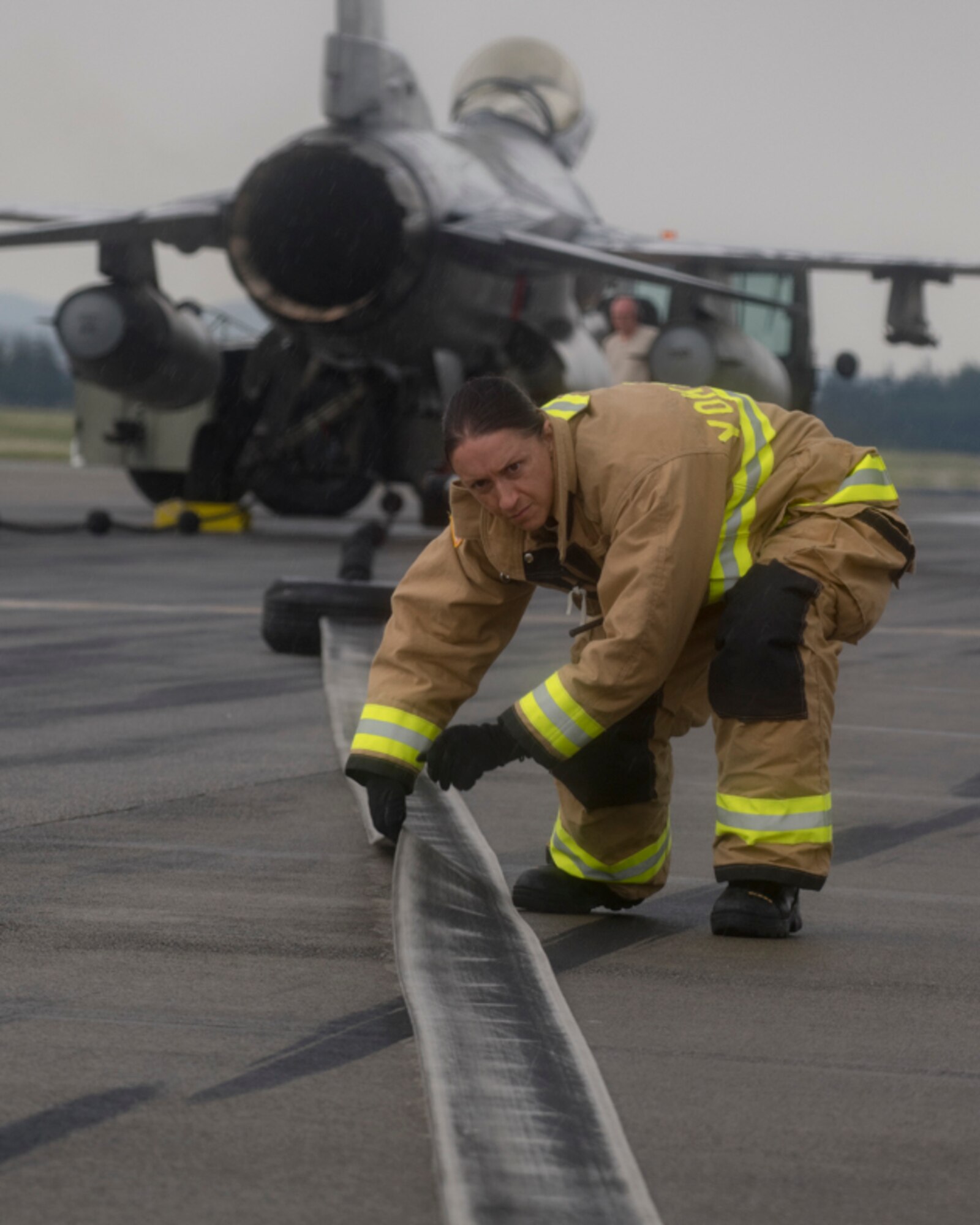 Tech. Sgt. Stephanie Hersey, 374th Civil Engineer Squadron firefighter, checks the nylon tape from the Aircraft Arresting System during an annual certification test at Yokota Air Base, Japan, June 1, 2017. The 374 CES power productions shop, fire department and 374th Operations Support Squadron airfield management flight are responsible for testing the system annually. (U.S. Air Force photo by Yasuo Osakabe)
