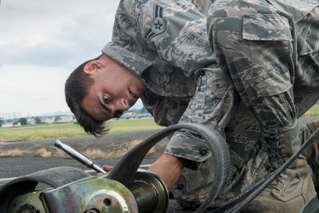Airman 1st Class Zachary Sheller, 374th Civil Engineer Squadron electrical power plant journeyman, checks an arresting gear at Yokota Air Base, Japan, June 1, 2017, during an annual certification test of the Aircraft Arresting System. Airmen from the 374 CES and 374th Operations Support Squadron are responsible for setting up the system and logging any deficiencies during the test. (U.S. Air Force photo by Yasuo Osakabe)