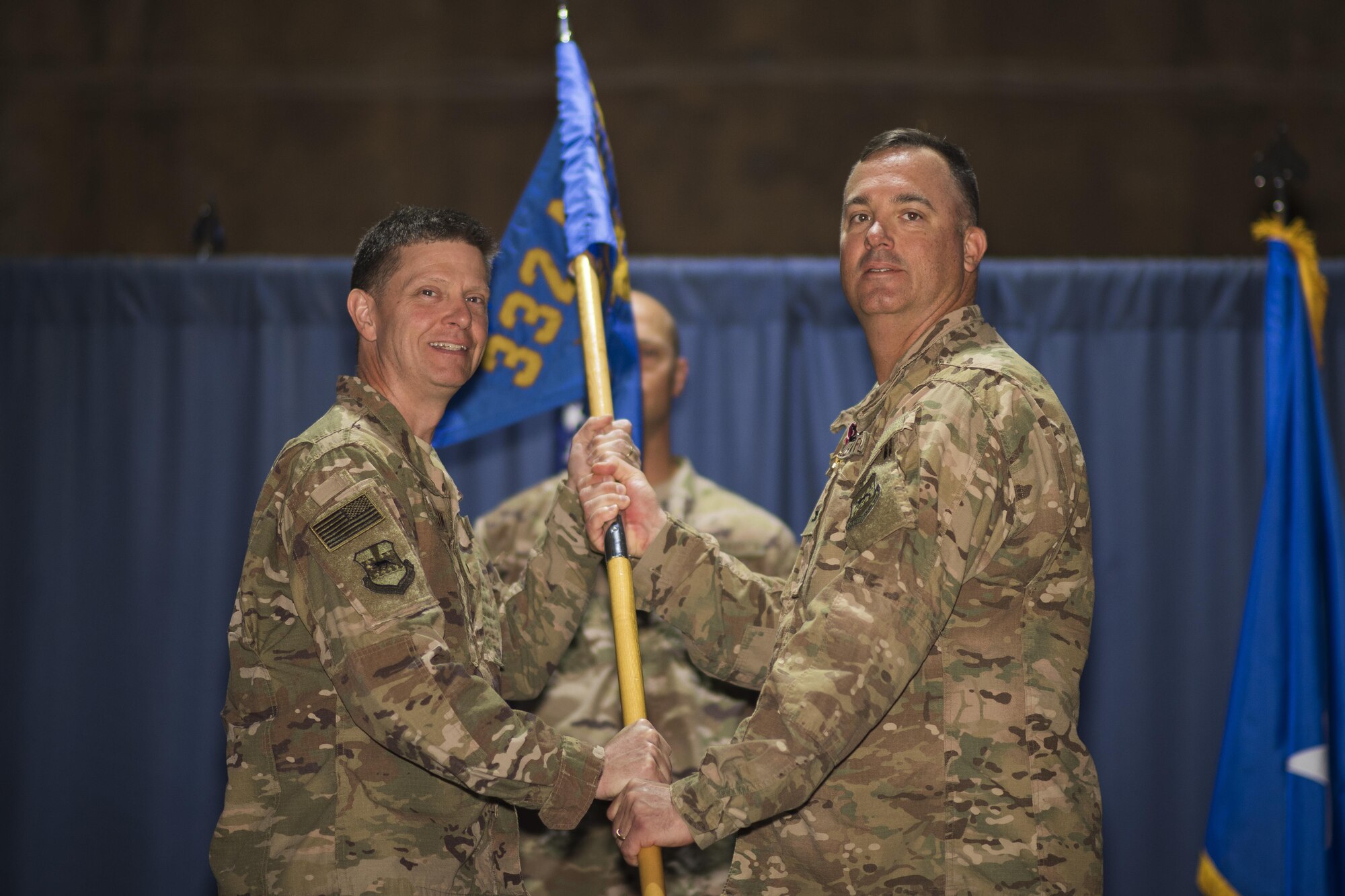 Col. Daniel A. Guinan, 332nd Expeditionary Mission Support Group commander, right, relinquishes the guidon to Brig. Gen. Kyle W. Robinson, 332nd Air Expeditionary Wing commander, during a change of command ceremony June 4, 2017 in Southwest Asia. The passing of a unit’s guidon symbolizes a transfer of command. (U.S. Air Force photo/Senior Airman Damon Kasberg)