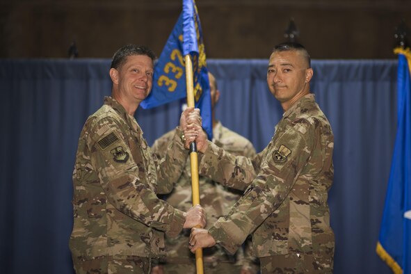 Brig. Gen. Kyle W. Robinson, 332nd Air Expeditionary Wing commander, left, passes the guidon to Col. Christopher K. Fuller, during the 332nd Expeditionary Mission Support Group change of command ceremony June 4, 2017, in Southwest Asia. The passing of a guidon symbolizes a unit’s transfer of command. (U.S. Air Force photo/Senior Airman Damon Kasberg)