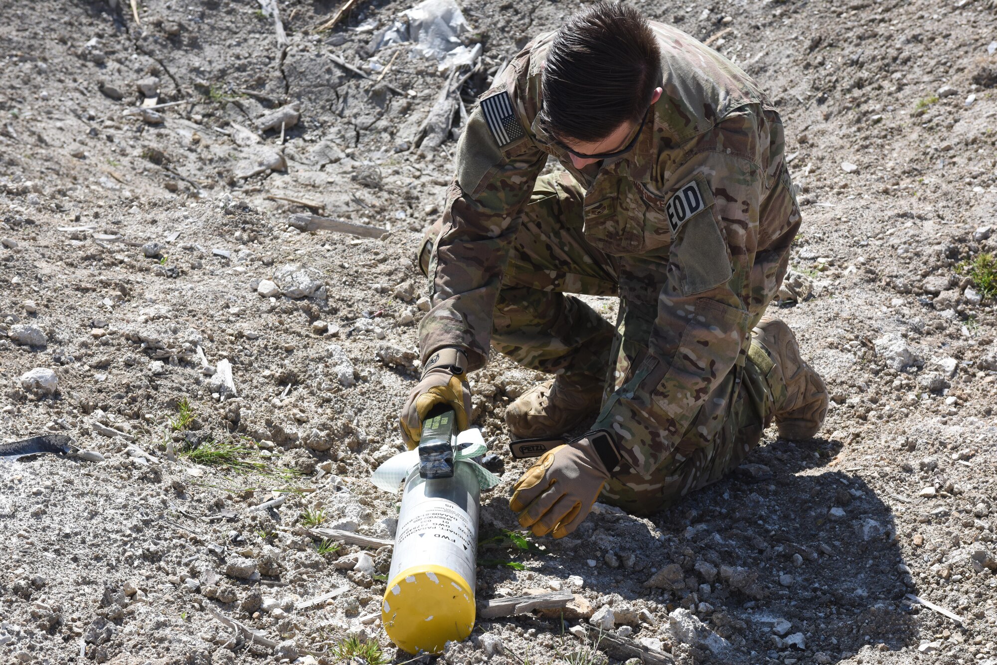 An explosive ordnance disposal technician assigned to the 48th Civil Engineer Squadron attaches a piece of C-4 plastic explosive to an expired piece of ammunition at Salisbury Plain Training Area, Wiltshire, England, May 24. EOD technicians from RAF Lakenheath disposed of over 2,500 pieces of expired munitions. (U.S. Air Force photo/Airman 1st Class Eli Chevalier)