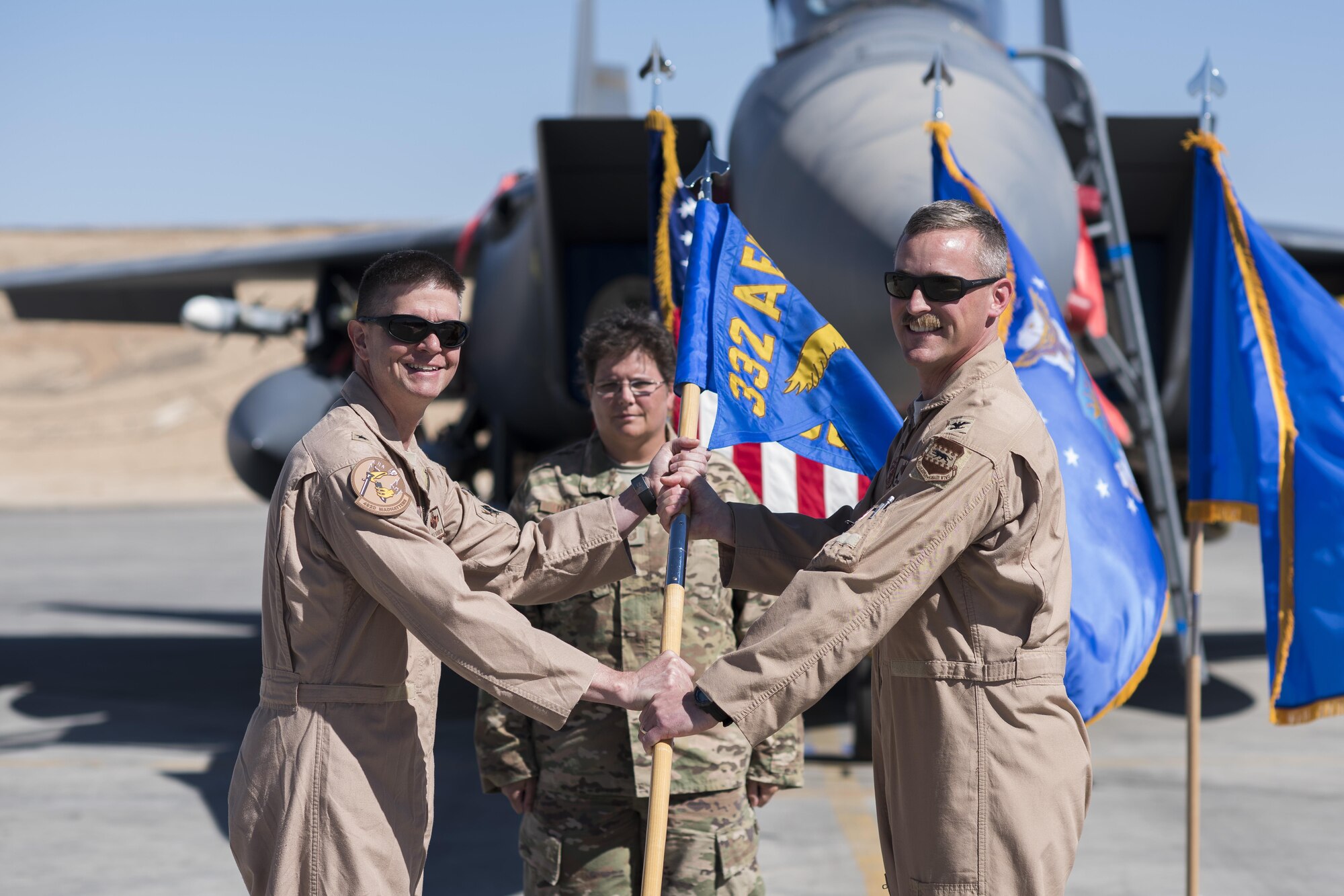 Col. Thomas S. Palmer, 332nd Expeditionary Operations Group commander, right, relinquishes the guidon to Brig. Gen. Kyle W. Robinson, 332nd Air Expeditionary Wing commander, during a change of command ceremony June 7, 2017, in Southwest Asia. The passing of a unit’s guidon symbolizes a transfer of command. (U.S. Air Force photo/Senior Airman Damon Kasberg)