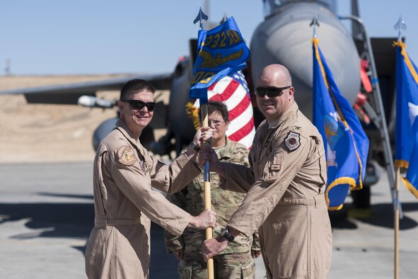 Brig. Gen. Kyle W. Robinson, 332nd Air Expeditionary Wing commander, left, passes the guidon to Col. William L. Marshall, during the 332nd Expeditionary Operations Group change of command ceremony June 7, 2017, in Southwest Asia. The passing of a guidon symbolizes a unit’s transfer of command. (U.S. Air Force photo/Senior Airman Damon Kasberg)