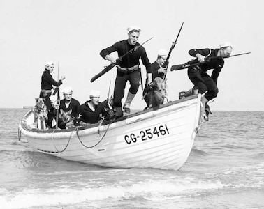 Dogs and their beach patrol handlers leap into action from a surfboat during a landing exercise along the coast of South Carolina, circa 1943.

Uniform Landing Force: undress blue with leggings