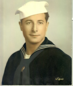 Dress blues with white "Dixie Cup" hat; this was a typical uniform combination worn while on liberty.  This uniform was the same as worn by Navy sailors except for the shield device, in white, on the lower right sleeve. 
The Coast Guardsman is Frank Salvucci, USCGR
