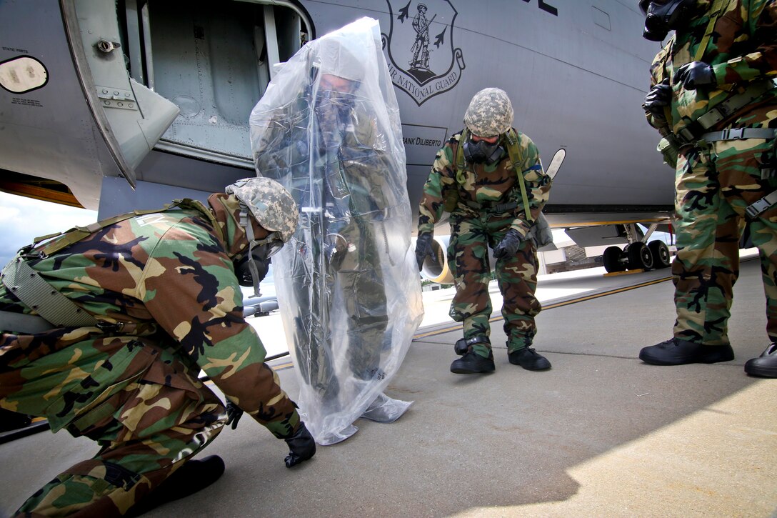 New Jersey Air National Guardsmen place 1st Lt. Beau Deleon into a protective covering after exiting a KC-135 Stratotanker aircraft during an exercise at Joint Base McGuire-Dix-Lakehurst, N.J., June 7, 2017. Deleon is a pilot assigned to the 141st Air Refueling Squadron. Air National Guard photo by Master Sgt. Matt Hecht