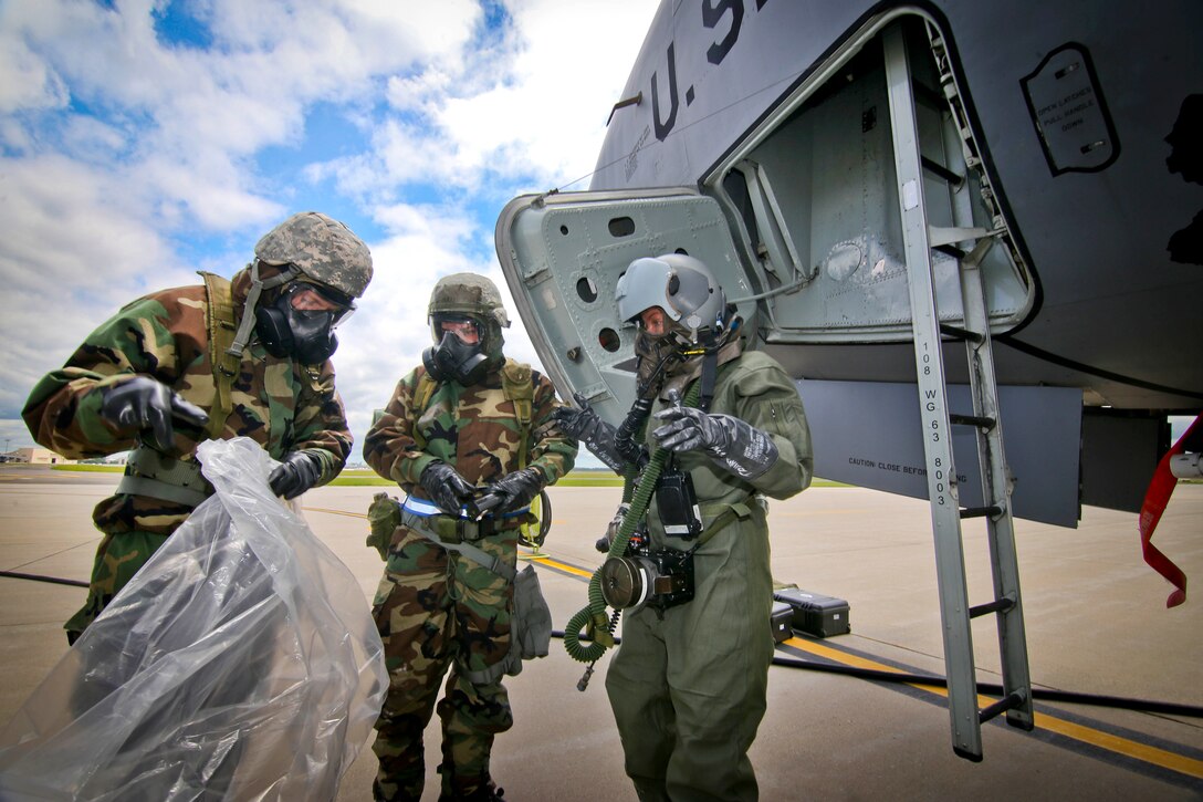 Airmen assigned to the New Jersey Air National Guard's 108th Wing place Senior Airman Kimberly Moncayo into protective gear during an exercise at Joint Base McGuire-Dix-Lakehurst, N.J., June 7, 2017. Moncayo is a KC-135 Stratotanker boom operator with the 141st Air Refueling Squadron. Air National Guard photo by Master Sgt. Matt Hecht