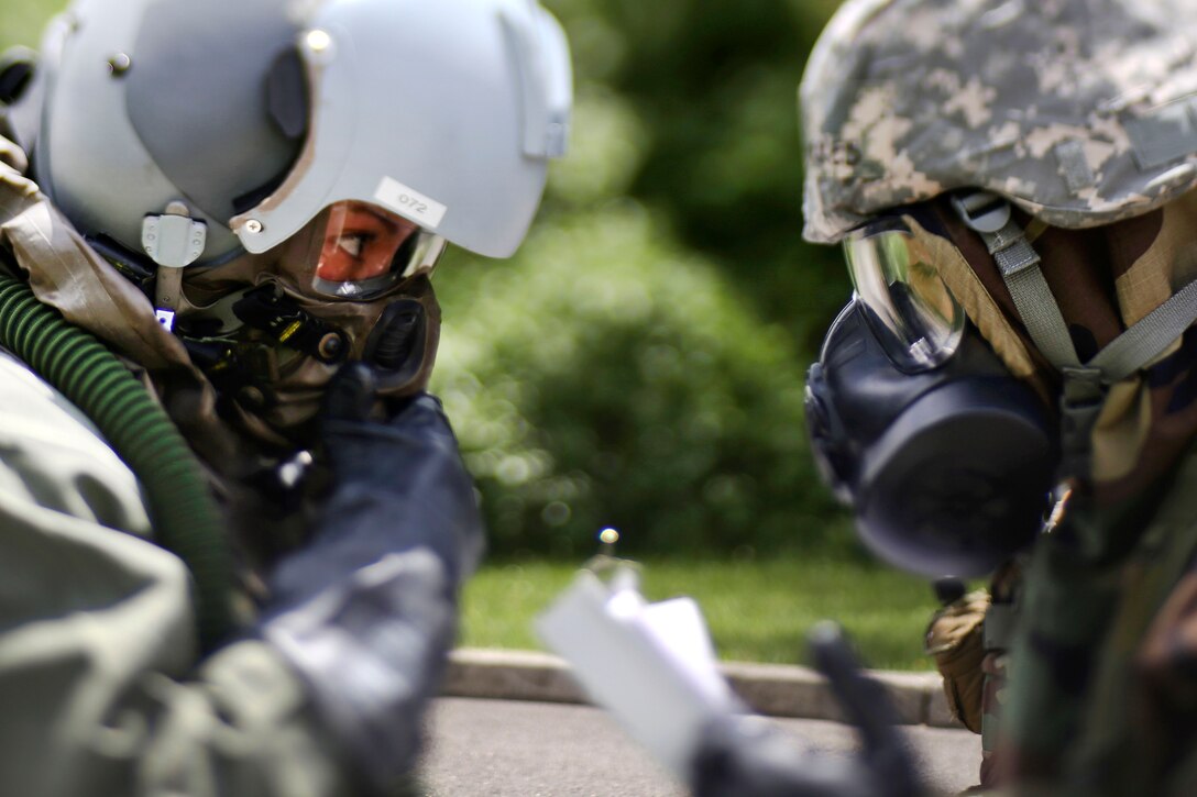 New Jersey Air National Guard Staff Sgt. Stephanie Torres, right, processes Senior Airman Kimberly Moncayo through the first station at the aircrew contamination control area during an exercise at Joint Base McGuire-Dix-Lakehurst, N.J., June 7, 2017. Torres and Moncayo are assigned to the 141st Air Refueling Squadron. Air National Guard photo by Master Sgt. Matt Hecht