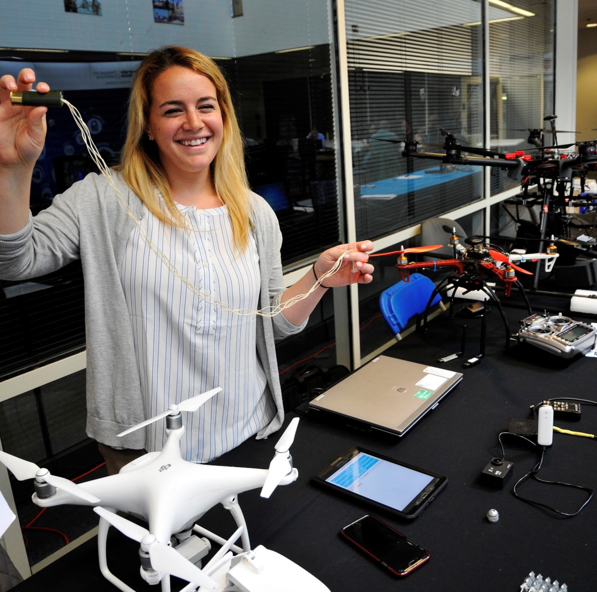 Hanna Timberlake, test engineer at Hanscom’s Space Fence program office, demonstrates a shotgun shell loaded with expanding strings potentially capable of taking down a small unmanned aerial vehicle at the Hanscom Innovation Event April 27, 2017. Timberlake and a team of six other engineers and program managers competed in the 2016 Air Force Research Laboratory’s Commander’s Challenge to build a developmental system capable of defending against small UAVs, with a six month deadline and $50,000 to invest.  (U.S. Air Force photo by Benjamin Newell)