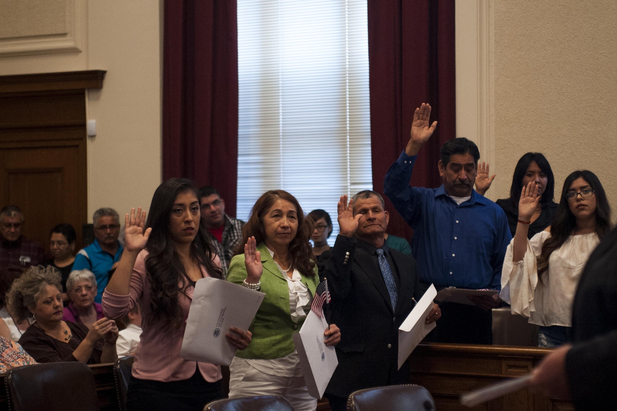 Newly nationalized American citizens swear an oath of citizenship in the O.C. Fisher Building, San Angelo, Texas, June 7, 2017. The naturalization ceremony gave citizenship to individuals from almost every part of the world including Mexico, China, Malaysia, Brazil and Nicaragua. (U.S. Air Force photo by Senior Airman Scott Jackson/Released)