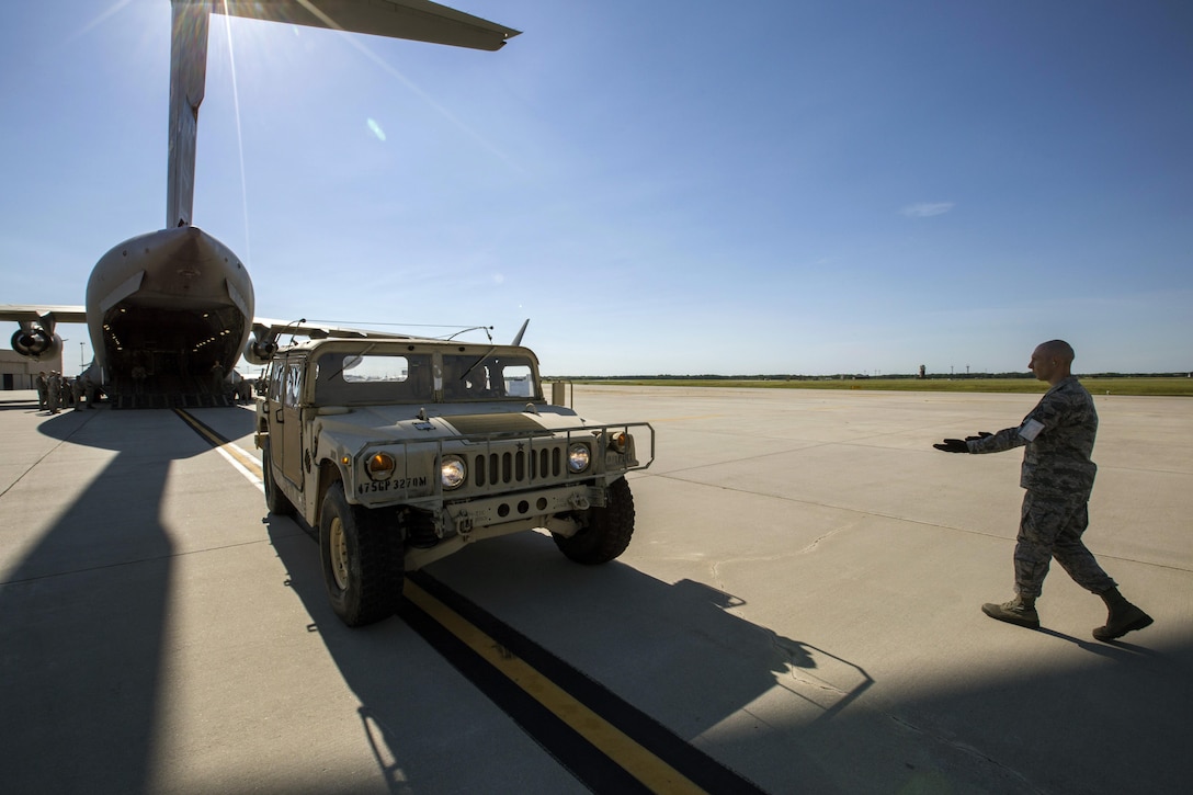 A U.S. Air Force Aerial Porter with the 35th Aerial Port Squadron, 514th Air Mobility Wing, marshals a Humvee onto a U.S. Air Force C-17 Globemaster III during a joint mobility exercise with the 851st Transportation Detachment, U.S. Army Reserve, at Joint Base McGuire-Dix-Lakehurst, N.J., June 4, 2017. The aerial porters loaded two Humvees and a Heavy Expanded Mobility Tactical Truck Recovery Truck onboard a C-17, which is assigned to the 305th Air Mobility Wing and is maintained and flown by the 514th Air Mobility Wing, Air Force Reserve Command. (U.S. Air Force photo by Master Sgt. Mark C. Olsen/Released)