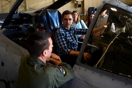 Thomas Johnson, an operations research analyst with the Cost Analysis and Program Evaluation office, sits in the pilot’s seat of an A-10 Thunderbolt II aircraft while talking about the aircraft’s capabilities with Air Force Lt. Col. Rich Hunt, left, a pilot with the Maryland Air National Guard’s 104th Fighter Squadron, as other members of CAPE look on during a visit to Warfield Air National Guard Base, Maryland, June 1, 2017. 