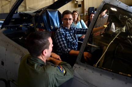 Thomas Johnson, an operations research analyst with the Cost Analysis and Program Evaluation office, sits in the pilot’s seat of an A-10 Thunderbolt II aircraft while talking about the aircraft’s capabilities with Air Force Lt. Col. Rich Hunt, left, a pilot with the Maryland Air National Guard’s 104th Fighter Squadron, as other members of CAPE look on during a visit to Warfield Air National Guard Base, Maryland, June 1, 2017. 