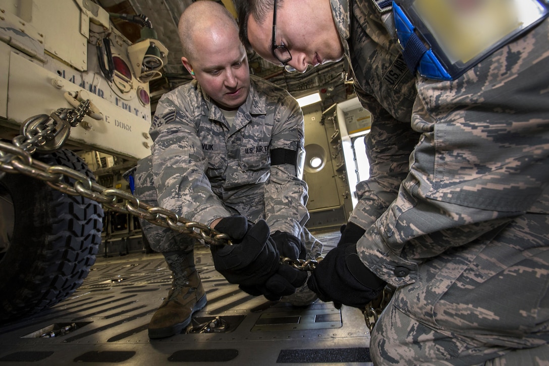 U.S. Air Force Aerial Porters Senior Airmen Christopher E. Pavlik, left, and Milton Calderon, both with the 35th Aerial Port Squadron, 514th Air Mobility Wing, chain down a Humvee during a joint mobility exercise with the 851st Transportation Detachment, U.S. Army Reserve, at Joint Base McGuire-Dix-Lakehurst, N.J., June 4, 2017. The aerial porters loaded two Humvees and a Heavy Expanded Mobility Tactical Truck Recovery Truck onboard a C-17, which is assigned to the 305th Air Mobility Wing and is maintained and flown by the 514th Air Mobility Wing, Air Force Reserve Command. (U.S. Air Force photo by Master Sgt. Mark C. Olsen/Released)