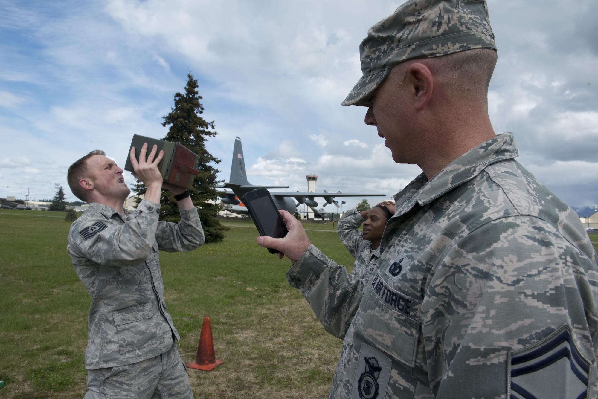 Senior Master Sgt. Eric Hall, 673d Security Forces integrated defense superintendent times Tech. Sgt. Joshua Hefley, 673d SFS Falcon Flight sergeant as he lifts a full ammunition canister 91 times at the Elmendorf Fitness Center, May 25, 2017. In the back, Senior Airman Michala Jordan cheers Hefley on as she rests from her 91 repetition set. 