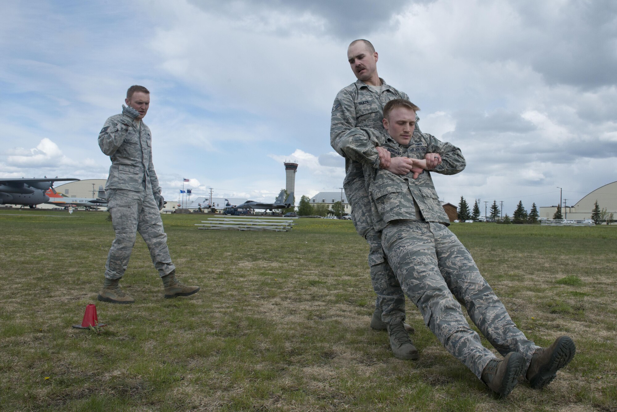 Airman 1st Class Jared Brazil drags Air Force Staff Sgt. Christopher Bonham through a cone course, guided by Tech. Sgt. Joshua Hefley, all a part of the 673d Security Forces Squadron, at the Elmendorf Fitness Center, May 25, 2017. Though they train many ways throughout their 30-day training period, this day was modeled after the Marines' combat fitness test. 