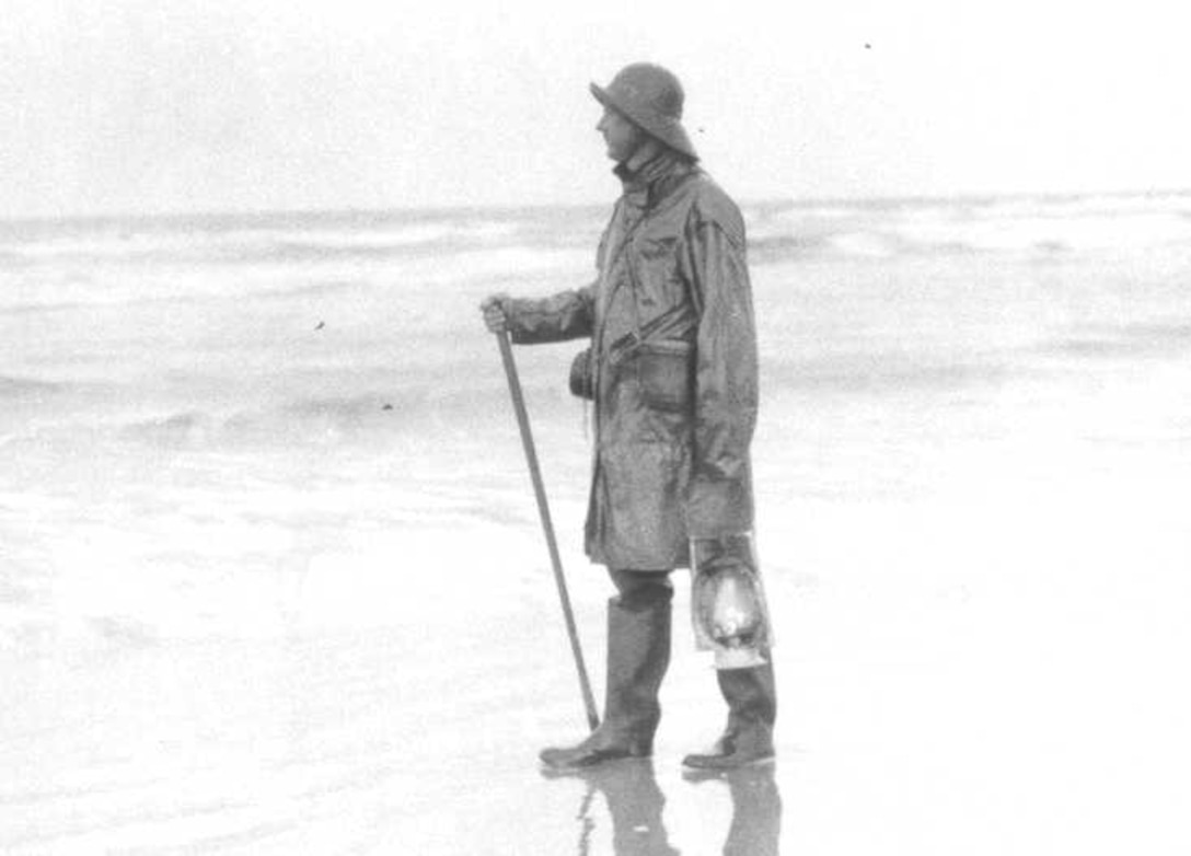 US Life Saving Service, Standard "storm suit," no date, with walking stick and lantern.