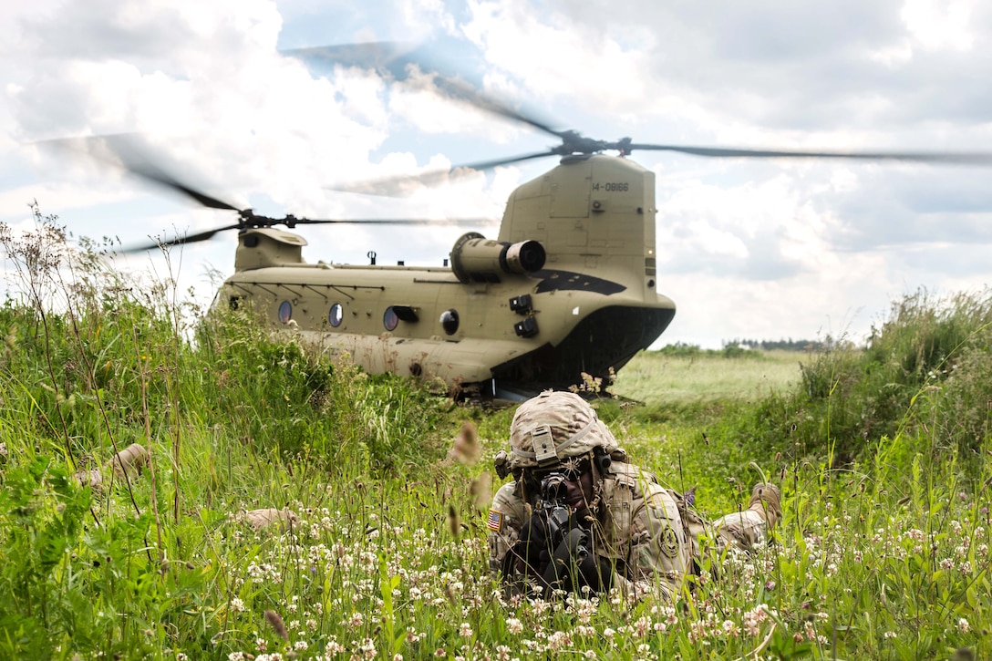A soldier provides security near a CH-47 Chinook helicopter during exercise Saber Strike 2017, at Bemowo Piskie Training Area near Orzysz, Poland, June 7, 2017. Army photo by Spc. Stefan English