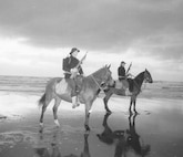 Mounted Beach Patrol: foul weather gear.  
Note the radio on the back of the Coast Guardsman in the foreground.


