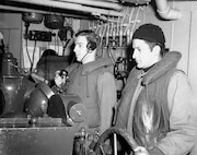 Helmsman and talker on the bridge of a cutter at sea in the North Atlantic, WWII
