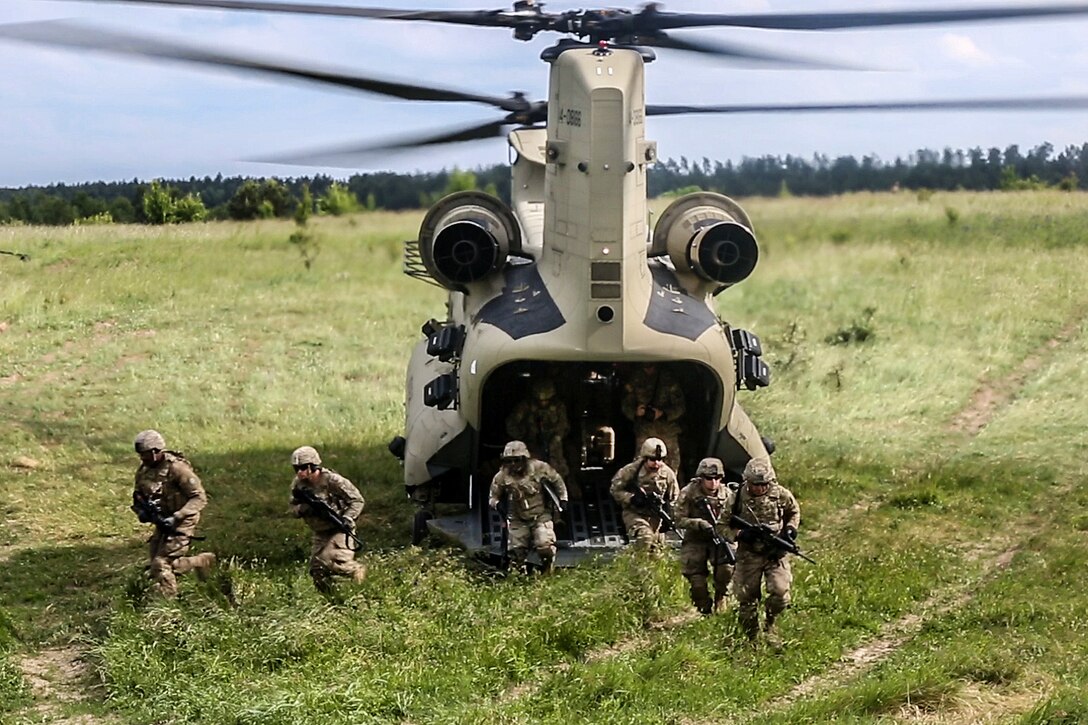 Solders exit from a CH-47 Chinook helicopter during training as part of exercise Saber Strike 2017, at Bemowo Piskie Training Area near Orzysz, Poland, June 7, 2017. Army photo by Spc. Stefan English