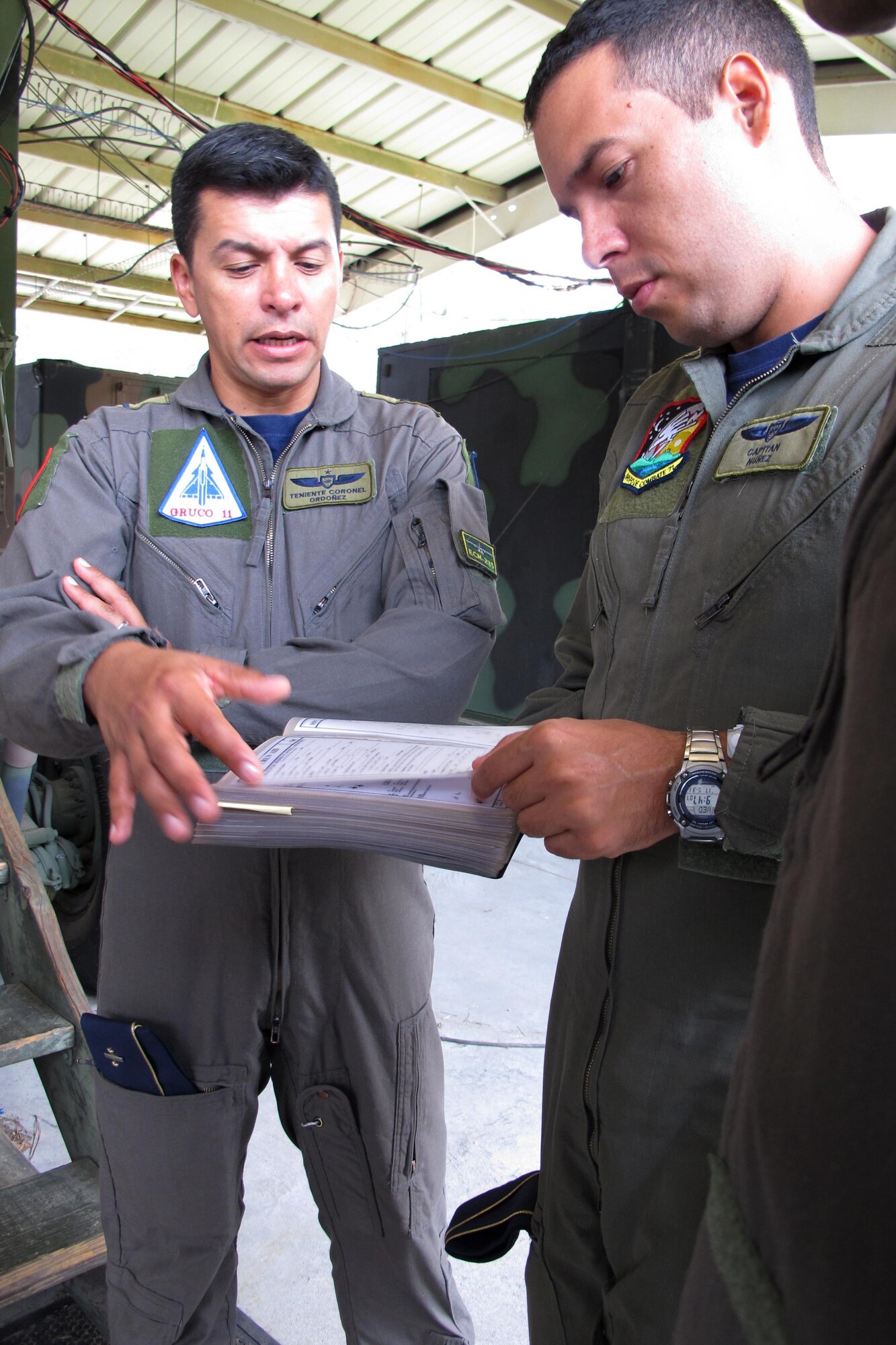Colombian Air Force Lt. Col. Jorge Ordonez (left) and Colombian Air Force Capt, Rodrigo Nunez look over Ground Control Intercept training manuals at the Georgia Air National Guard 117th Air Control Squadron at Hunter Army Airfield in Savannah, Georgia May 30-June 2, 2017 during a State Partnership Program engagement with the South Carolina National Guard. (U.S. Air National Guard photo by Capt. Stephen D. Hudson)