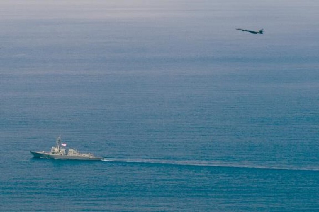 An Air Force B-1B Lancer strategic bomber assigned to the 9th Expeditionary Bomb Squadron flies over Arleigh Burke-class guided-missile destroyer USS Sterett (DDG 104) as the ship and aircraft operate in the South China Sea. Sterett is part of the Sterett-Dewey Surface Action Group and is the third deploying group operating under the command and control construct called 3rd Fleet Forward. U.S. 3rd Fleet operating forward offers additional options to the Pacific Fleet commander by leveraging the capabilities of 3rd and 7th Fleets. (U.S. Navy photo by Mass Communication Specialist 1st Class Byron C. Linder/Released)