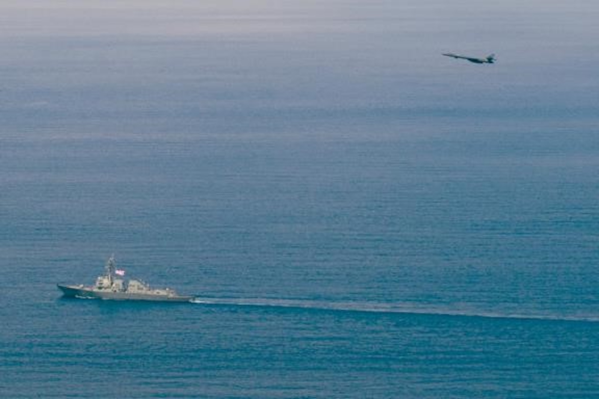 An Air Force B-1B Lancer strategic bomber assigned to the 9th Expeditionary Bomb Squadron flies over Arleigh Burke-class guided-missile destroyer USS Sterett (DDG 104) as the ship and aircraft operate in the South China Sea. Sterett is part of the Sterett-Dewey Surface Action Group and is the third deploying group operating under the command and control construct called 3rd Fleet Forward. U.S. 3rd Fleet operating forward offers additional options to the Pacific Fleet commander by leveraging the capabilities of 3rd and 7th Fleets. (U.S. Navy photo by Mass Communication Specialist 1st Class Byron C. Linder/Released)