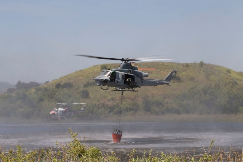 U.S. Marine Corps UH-1Y Venom, right, and the CAL FIRE Bell 407 helicopter, left, collect lake water during the 2017 Wildland Firefighting Exercise (WLFFEX) at Lake O'Neill on Camp Pendleton, Calif., May 4, 2017. The WLFFEX is an annual training event to exercise the firefighting efforts by aviation and ground assests from Marine Corps Installations - West, Marine Corps Base, Camp Pendleton, 3rd Marine Aircraft Wing, Navy Region South West, Third Fleet, CAL FIRE, and San Diego County Sheriff's Department. (U.S. Marine Corps photo by Cpl. Brandon Martinez)