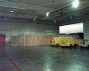 Air Station Cape Cod, Massachusetts
Original photo caption: "The wooden wall that conceals the wreckage of John F. Kennedy's Piper Saratoga airplane [in] Air Station Cape Cod's hangar.  John F. Kennedy Jr., his wife Carolyn and her sister Lauren Bessette . . . died when Kennedy's [aircraft] crashed into the sea July 17."; photo is dated 22 July 1999; photo number 990722-I-5644M-501 (FR); photo by PA1 Pete Milnes, USCG.
