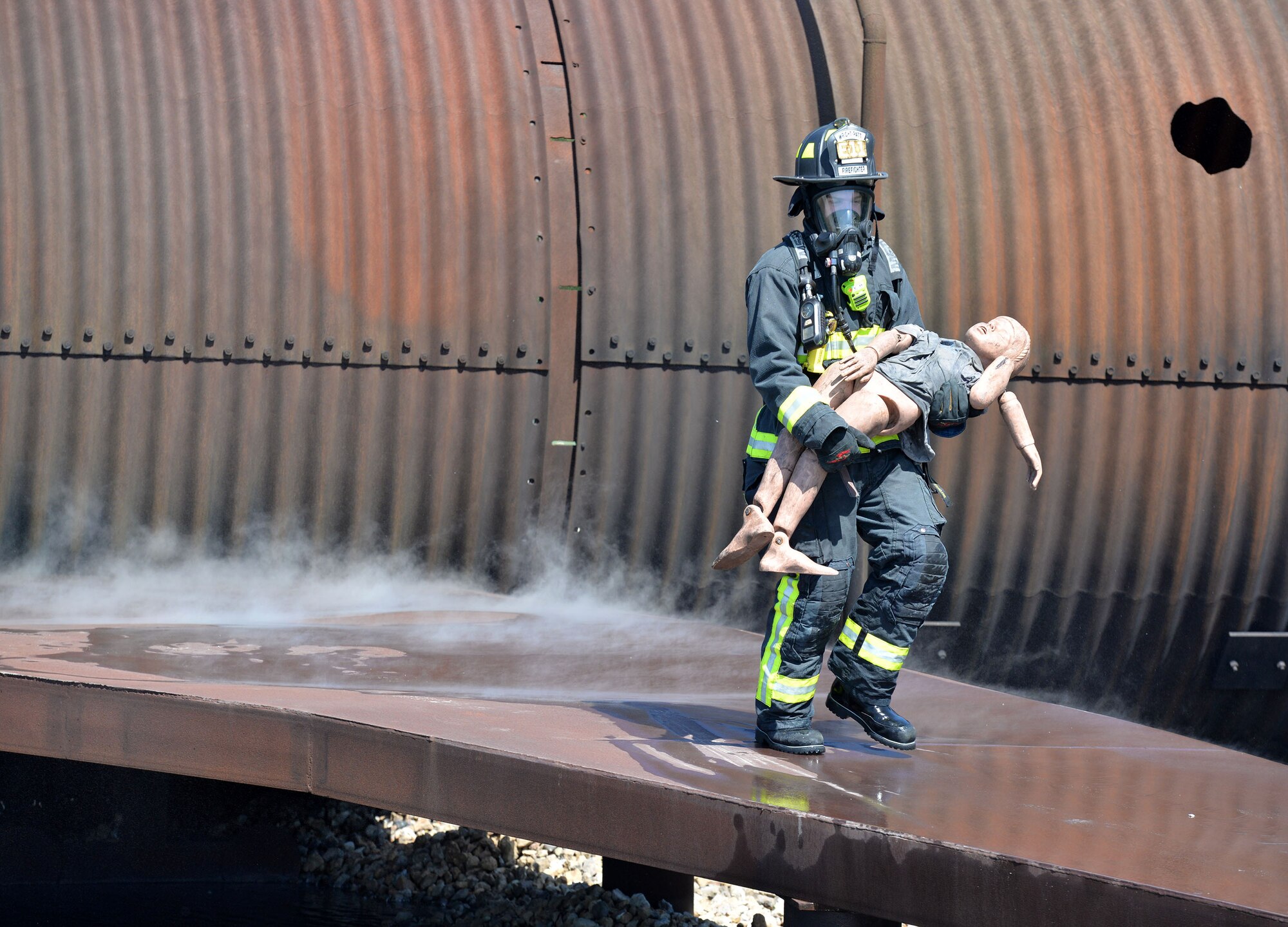 Richard Breitenstein 788th Civil Engineer Squadron firefighter, carries a mannequin from an aircraft after successfully putting out a fire inside their training burn pit, May 30, 2017 at Wright-Patterson Air Force Base, Ohio. Crews extinguished two different kinds of aircraft fires in addition to conducting searches for victims as part of their annual proficiency skill training for firefighters. (U.S. Air Force photo/Michelle Gigante) 