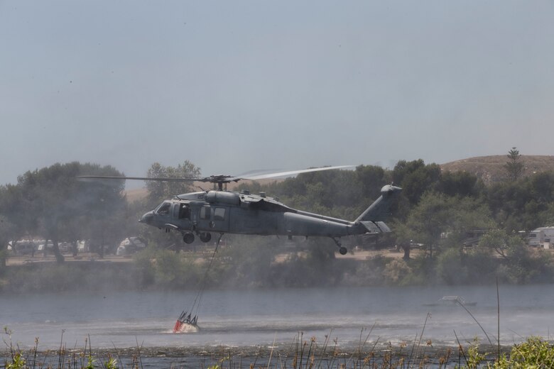 U.S. Navy Seahawk 60 helicopter lowers it's bambi bucket to collect lake water during the 2017 Wildland Firefighting Exercise (WLFFEX) at Lake O'Neill on Camp Pendleton, Calif., May 4, 2017. The WLFFEX is an annual training event to exercise the firefighting efforts by aviation and ground assests from Marine Corps Installations - West, Marine Corps Base, Camp Pendleton, 3rd Marine Aircraft Wing, Navy Region South West, Third Fleet, CAL FIRE, and San Diego County Sheriff's Department. (U.S. Marine Corps photo by Cpl. Brandon Martinez)