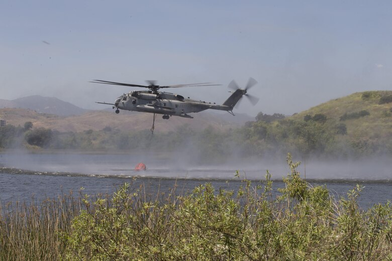 U.S. Marine Corps CH-53E Super Stallion lowers its bambi bucket to collect water during the 2017 Wildland Firefighting Exercise (WLFFEX) at Lake O'Neil on Camp Pendleton, Calif., May 4, 2017. The WLFFEX is an annual training event to exercise the firefighting efforts by aviation and ground assests from Marine Corps Installations - West, Marine Corps Base, Camp Pendleton, 3rd Marine Aircraft Wing, Navy Region South West, Third Fleet, CAL FIRE, and San Diego County Sheriff's Department. (U.S. Marine Corps photo by Cpl. Brandon Martinez)