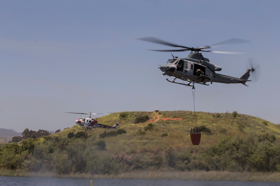 U.S. Marine Corps UH-1Y Venom, right, and the CAL FIRE Bell 407 helicopter, left, collect lake water during the 2017 Wildland Firefighting Exercise (WLFFEX) at Lake O'Neill on Camp Pendleton, Calif., May 4, 2017. The WLFFEX is an annual training event to exercise the firefighting efforts by aviation and ground assests from Marine Corps Installations - West, Marine Corps Base, Camp Pendleton, 3rd Marine Aircraft Wing, Navy Region South West, Third Fleet, CAL FIRE, and San Diego County Sheriff's Department. (U.S. Marine Corps photo by Cpl. Brandon Martinez)