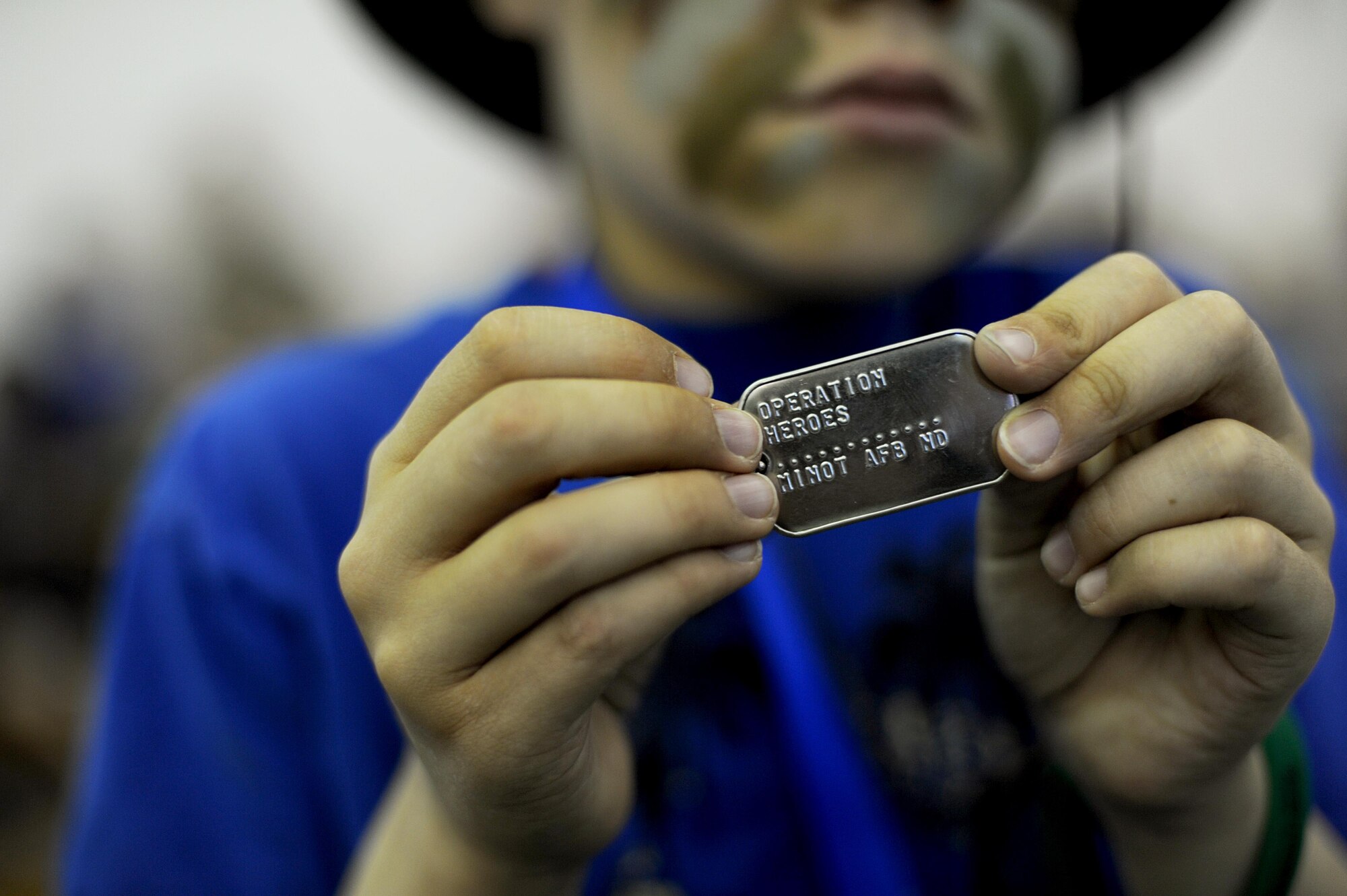 Ashton Trujillo shows off his Operation Heroes dog tags at Minot Air Force Base, N.D., June 3, 2017. Children from the base participated in Operation Heroes which gives them a taste of what it’s like to deploy like their parents. (U.S. Air Force Photo by Staff Sgt. Chad Trujillo)