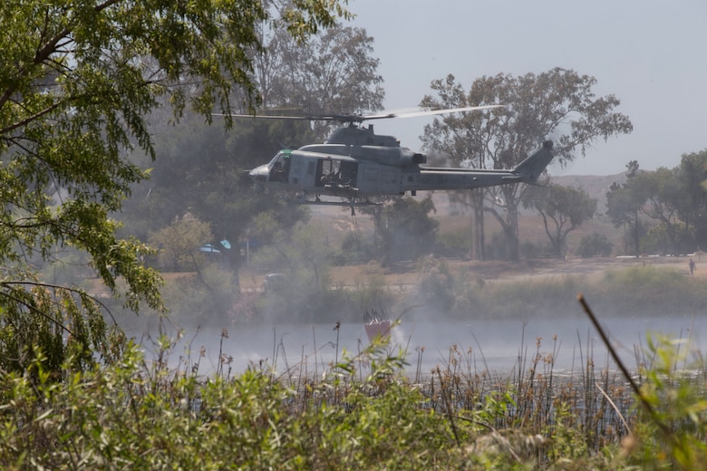 U.S. Marine Corps UH-1Y Venom collects lake water during the 2017 Wildland Firefighting Exercise (WLFFEX) at Lake O'Neill on Camp Pendleton, Calif., May 4, 2017. The WLFFEX is an annual training event to exercise the firefighting efforts by aviation and ground assests from Marine Corps Installations - West, Marine Corps Base, Camp Pendleton, 3rd Marine Aircraft Wing, Navy Region South West, Third Fleet, CAL FIRE, and San Diego County Sheriff's Department. (U.S. Marine Corps photo by Cpl. Brandon Martinez)