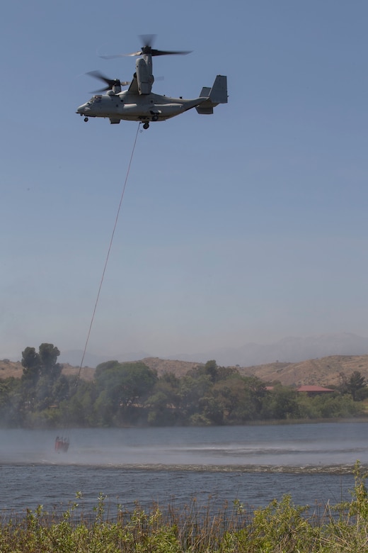 U.S. Marine Corps MV-22 Osprey lowers it's bambi bucket to collect lake water during the 2017 Wildland Firefighting Exercise (WLFFEX) at Lake O'Neill on Camp Pendleton, Calif., May 4, 2017. The WLFFEX is an annual training event to exercise the firefighting efforts by aviation and ground assests from Marine Corps Installations - West, Marine Corps Base, Camp Pendleton, 3rd Marine Aircraft Wing, Navy Region South West, Third Fleet, CAL FIRE, and San Diego County Sheriff's Department. (U.S. Marine Corps photo by Cpl. Brandon Martinez)