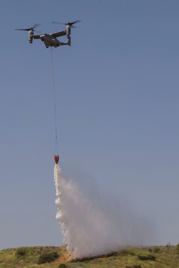 U.S. Marine Corps MV-22 Osprey drops water on simulated fire area during the 2017 Wildland Firefighting Exercise (WLFFEX) at Lake O'Neil on Camp Pendleton, Calif., May 4, 2017. The WLFFEX is an annual training event to exercise the firefighting efforts by aviation and ground assests from Marine Corps Installations - West, Marine Corps Base, Camp Pendleton, Third Marine Air Wing, Navy Region South West, Third Fleet, CAL FIRE, and San Diego County Sheriff's Department. (U.S. Marine Corps photo by Cpl. Brandon Martinez)