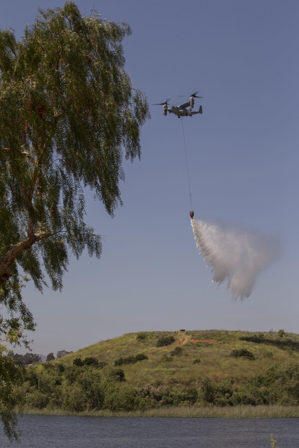 An MV-22 Osprey drops water during the 2017 Wildland Firefighting Exercise (WLFFEX) at Lake O'Neil on Camp Pendleton, Calif., May 4, 2017. The WLFFEX is an annual training event to exercise the firefighting efforts by aviation and ground assests from Marine Corps Installations - West, Marine Corps Base, Camp Pendleton, Third Marine Air Wing, Navy Region South West, Third Fleet, CAL FIRE, and San Diego County Sheriff's Department. (U.S. Marine Corps photo by Cpl. Brandon Martinez)