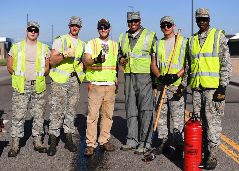 Chief Master Sgt. Rod Lindsey, 460th Space Wing command chief, poses with the 460th Civil Engineer Squadron Dirtboyz after spending their morning filling cracks in the roads June 8, 2017 on Buckley Air Force Base, Colo. One of Lindsey’s initiatives as command chief is experiencing the jobs of Team Buckley Airmen first hand. (U.S. Air Force photo by Staff Sgt. Andrew Helmkamp/ Released)