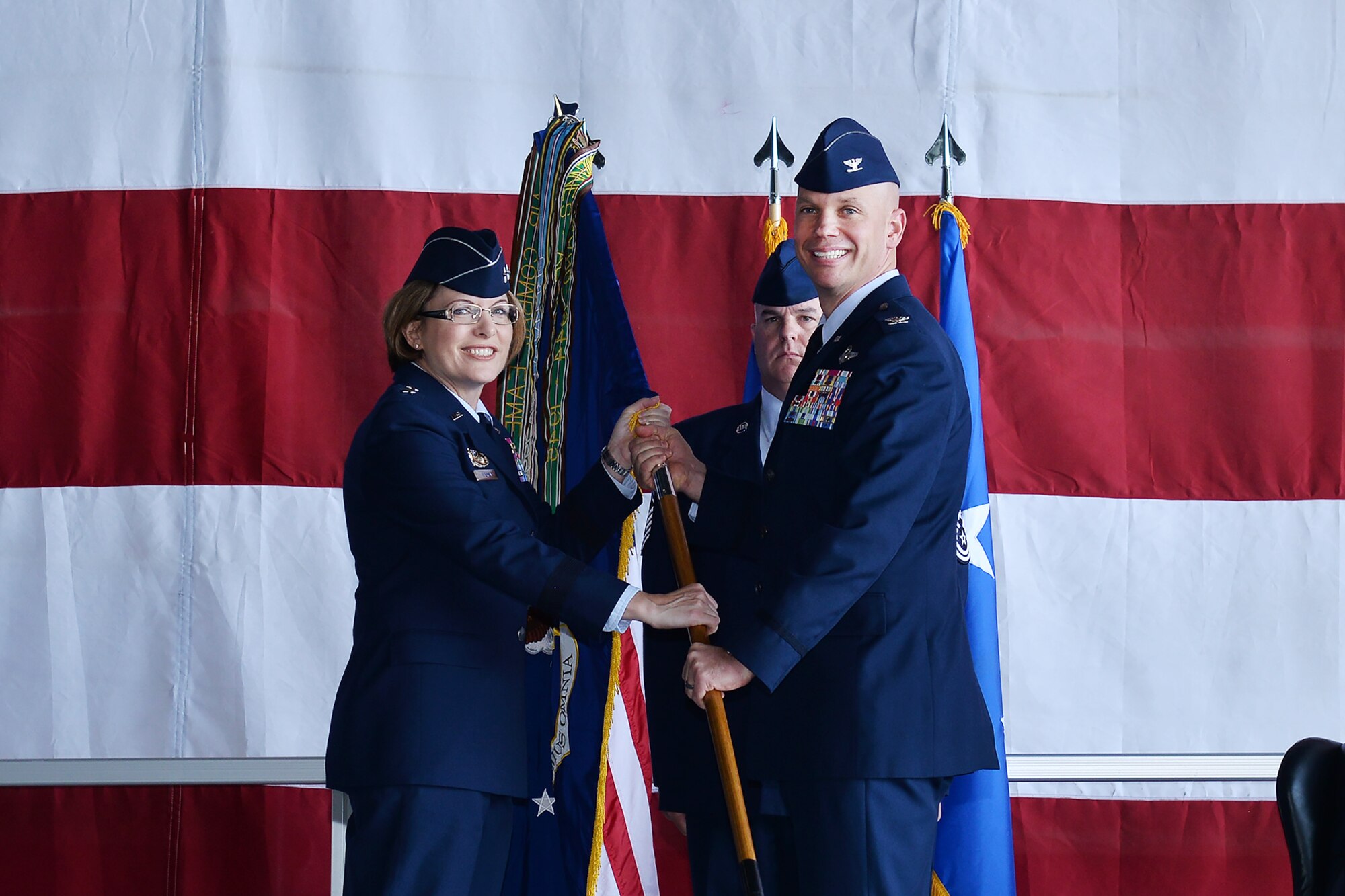Maj. Gen. Mary F. O’Brien, 25th Air Force commander, presents Col. Michael Manion with the 55th Wing guidon during a chang of command ceremony in Dock 1 of the Bennie Davis Maintenance Facility June 8. The Fightin' Fifty-Fifth said farewell to Col. Marty Reynolds and welcomed Col. Manion.