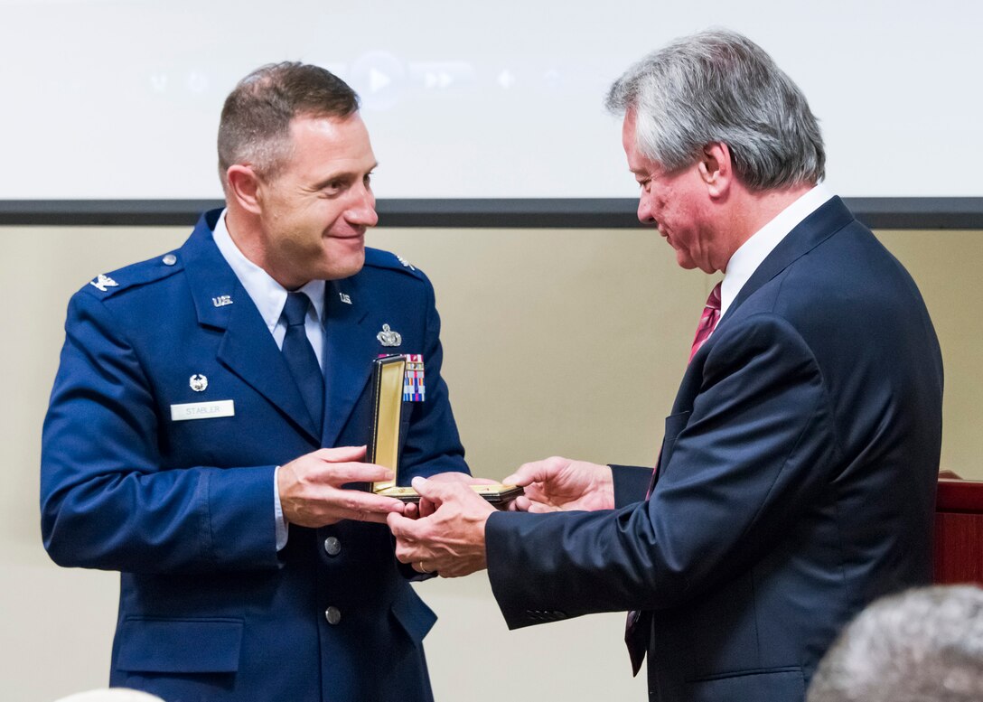 Col. Kirk B. Stabler, Air Force Office of Special Investigations Commander, presents the Bronze Star Medal of Fallen Special Agent Lee Hitchcock to his brother, Mr. Craig Hitchcock, during the OSI headquarters inaugural Celebration of Life Remembrance Ceremony May 22, 2017, at Quantico, Va. (U.S. Air Force photo/Mr. Michael Hastings)   