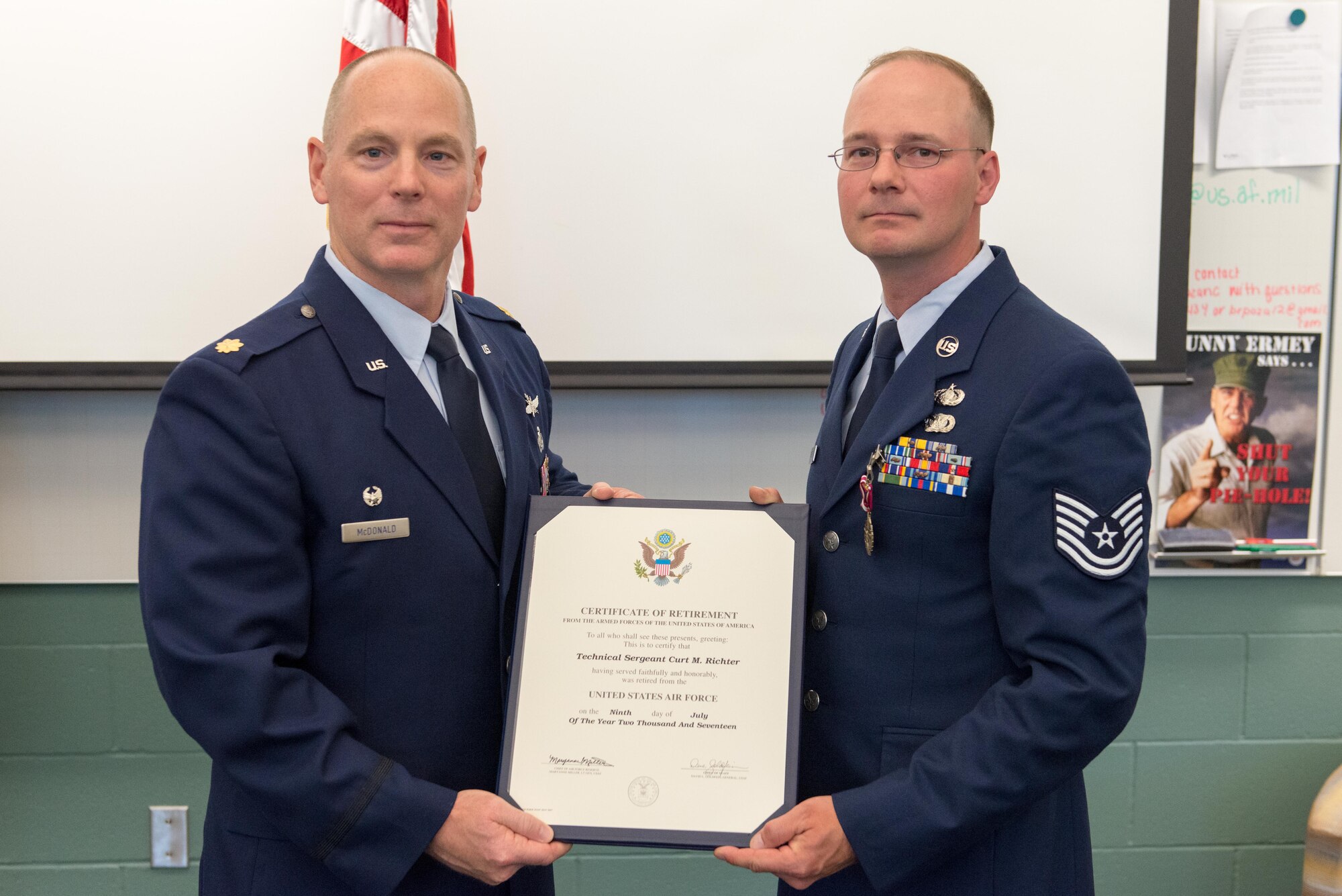 Tech. Sgt. Curt Richter receives his retirement certificate from Maj. Patrick McDonald, 934th Communications Squadron commander, June 3 at a ceremony at the Minneapolis-St. Paul Air Reserve Station. (Air Force Photo/Tech. Sgt. Trevor Saylor)