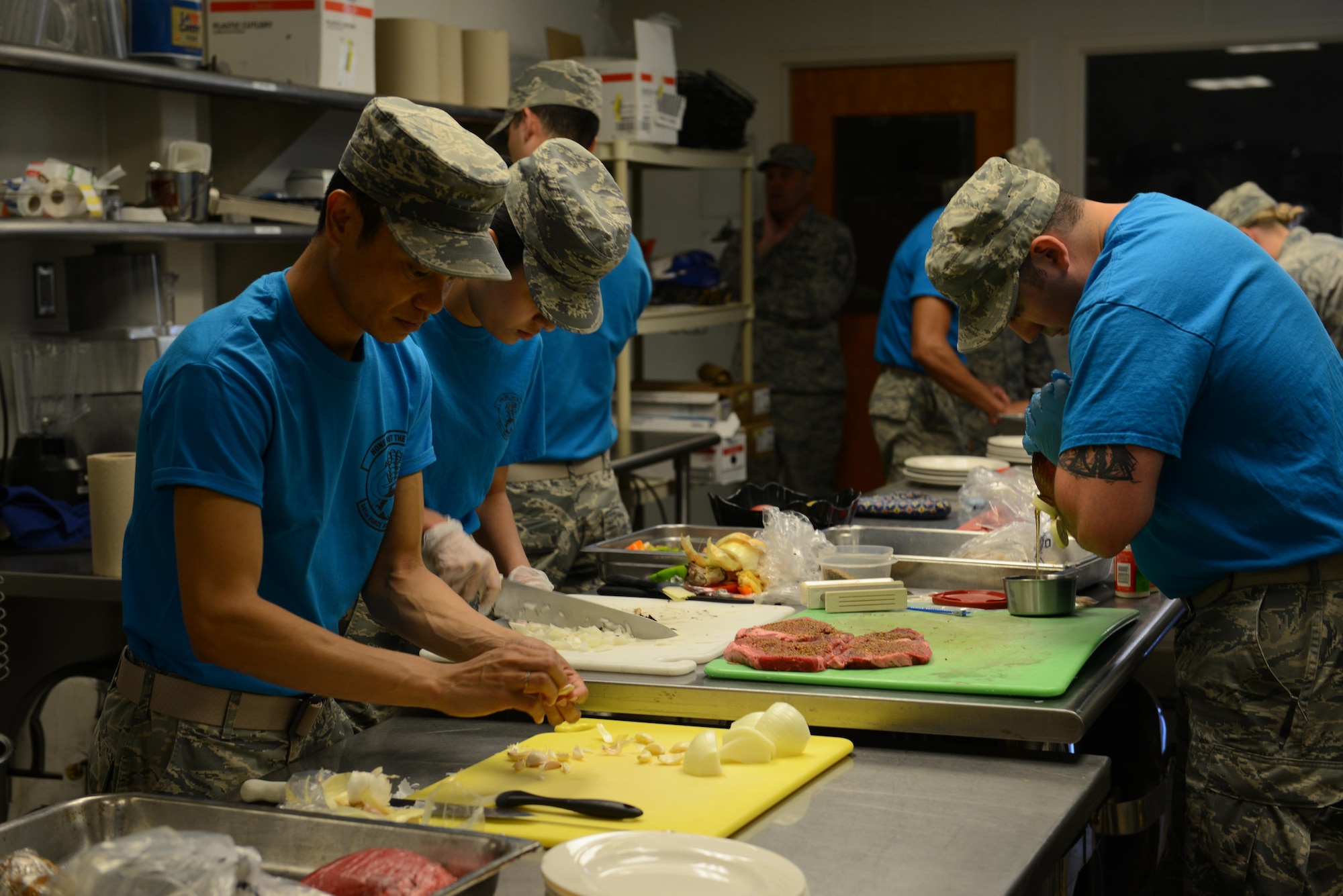 Airmen from the 341st Force Support Squadron work as teams of two to prepare meals from scratch during the Warrior Chef competition June 7, 2017 at Malmstrom Air Force Base, Mont. Each teams’ dishes were scored on taste, texture, tenderness, creativity, presentation and use of the secret ingredient. (U.S. Air Force photo/Staff Sgt. Delia Marchick)